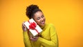 Happy african female holding present box with red bow, birthday gift surprise