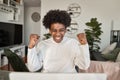 Happy African gen z student getting good news celebrating looking at laptop. Royalty Free Stock Photo