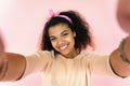 Happy african girl blogger take selfie look at mobile camera  on pink Royalty Free Stock Photo