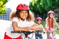 Happy African girl riding bicycle in summer city