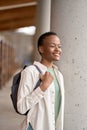 Happy African girl student holding backpack standing in library, vertical. Royalty Free Stock Photo