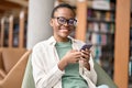 Happy African girl student wearing eyeglasses using mobile phone. Portrait. Royalty Free Stock Photo