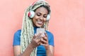 Happy african girl watching videos and listening music with mobile phone app - Young person having fun with new technology trends Royalty Free Stock Photo