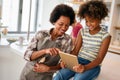 Happy african american preeteen girl using digital tablet for education, fun at home. Family concept