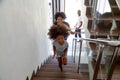 Happy african kid with parents running upstairs into new house Royalty Free Stock Photo