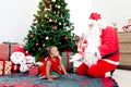 Happy African little girl child and Santa Claus under decorative Christmas tree, Santa Claus giving present gift box to cute kid Royalty Free Stock Photo