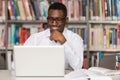 Happy African Male Student With Laptop In Library Royalty Free Stock Photo