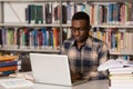 Happy African Male Student With Laptop In Library Royalty Free Stock Photo