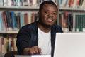 Happy African Male Student With Laptop In Library Royalty Free Stock Photo