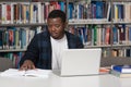 Happy African Male Student With Laptop In Library Royalty Free Stock Photo