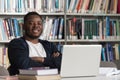 Happy African Male Student With Laptop In Library Royalty Free Stock Photo