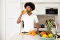 Happy African Man Drinking Orange Juice From Glass In Kitchen Royalty Free Stock Photo