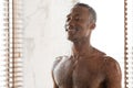 Happy african man taking cold shower refreshing in morning indoor Royalty Free Stock Photo