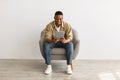 Happy African Man Using Digital Tablet Sitting Over Gray Background Royalty Free Stock Photo