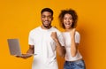Happy african man and woman enjoying lottery win with laptop Royalty Free Stock Photo