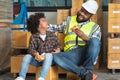 Happy African middle aged engineer worker beard man wear safety hat, eating burger in lunch break with his cute child son at