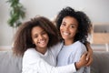 Happy african mother and teen daughter embracing looking at camera Royalty Free Stock Photo