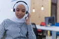 Happy african muslim woman in call center. Female Customer Service Representative Answer Client`s Questions in a Headset. Multi- Royalty Free Stock Photo