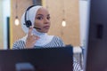 Happy african muslim woman in call center. Female Customer Service Representative Answer Client`s Questions in a Headset. Multi- Royalty Free Stock Photo