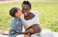 Happy African pregnant mother with son having tender moment in the park Royalty Free Stock Photo