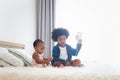 Happy African siblings in family, cute toddle baby infant with headphones listening music, brother boy with curly hair play with Royalty Free Stock Photo