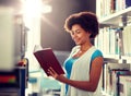 Happy african student girl reading book at library Royalty Free Stock Photo
