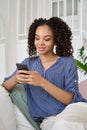 Happy African teen girl holding cell phone using smartphone at home. Royalty Free Stock Photo