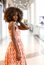 Happy african woman in beautiful dress in a shopping mall.