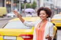 Happy african woman catching taxi