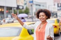 Happy african woman catching taxi