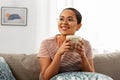 Happy african woman drinking tea or coffee at home Royalty Free Stock Photo