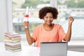 Happy african woman with laptop, books and diploma Royalty Free Stock Photo