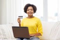 Happy african woman with laptop and credit card Royalty Free Stock Photo