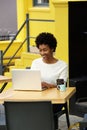 Happy african woman using laptop at cafe Royalty Free Stock Photo