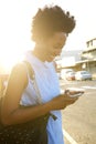 Happy african woman using mobile phone outdoors in the city Royalty Free Stock Photo