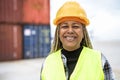 Happy African woman working in logistic terminal of container cargo