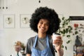 Happy African young woman cafe employee holding coffee cup, portrait. Royalty Free Stock Photo