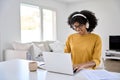 Happy African young woman student wearing headphones using computer elearning. Royalty Free Stock Photo