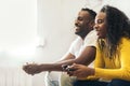 Happy afro american couple playing video game at home. side view Royalty Free Stock Photo