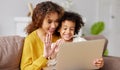 Happy afro american family mother and son having video call with family on laptop while spending time together at home