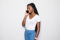 Happy young afro american woman talking on the phone and looking away over gray background Royalty Free Stock Photo