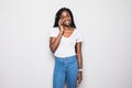 Happy young afro american woman talking on the phone and looking away over gray background Royalty Free Stock Photo