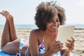 Happy afro american woman using tablet on beach Royalty Free Stock Photo