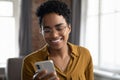 Happy Afro American young business woman in glasses using smartphone Royalty Free Stock Photo