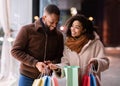 Happy afro couple holding shopping bags on the street Royalty Free Stock Photo