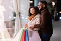 Happy afro couple with shopping bags looking at mall window Royalty Free Stock Photo