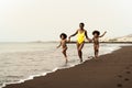 Happy Afro family having fun running on the beach during summer time