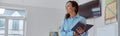 Happy afro female teacher with book in a light elementary school classroom Royalty Free Stock Photo