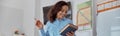 Happy afro female teacher with book in a light elementary school classroom Royalty Free Stock Photo