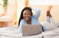 Afro Girl Making Video Call Via Laptop Lying In Bed Royalty Free Stock Photo